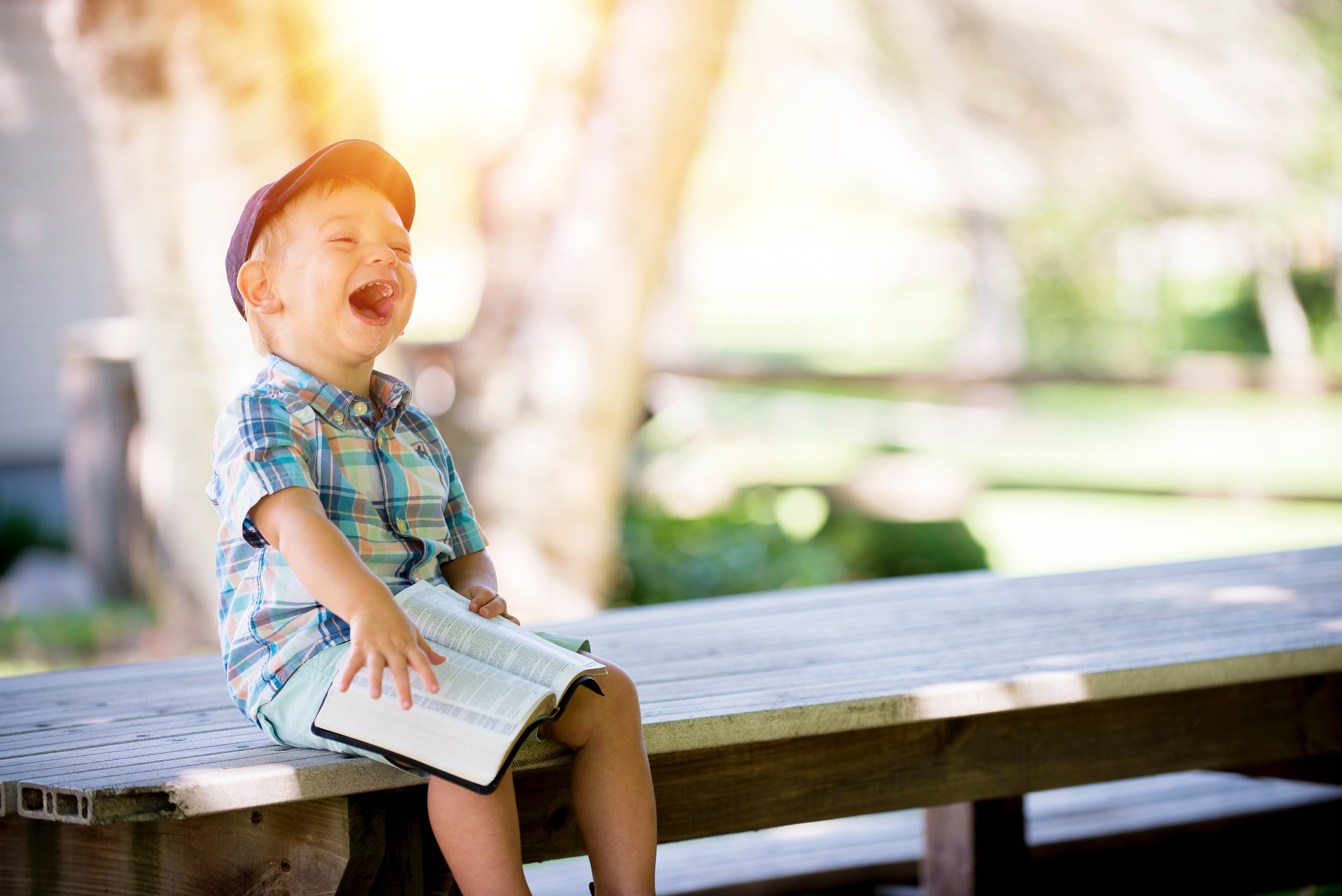 little boy reading outside