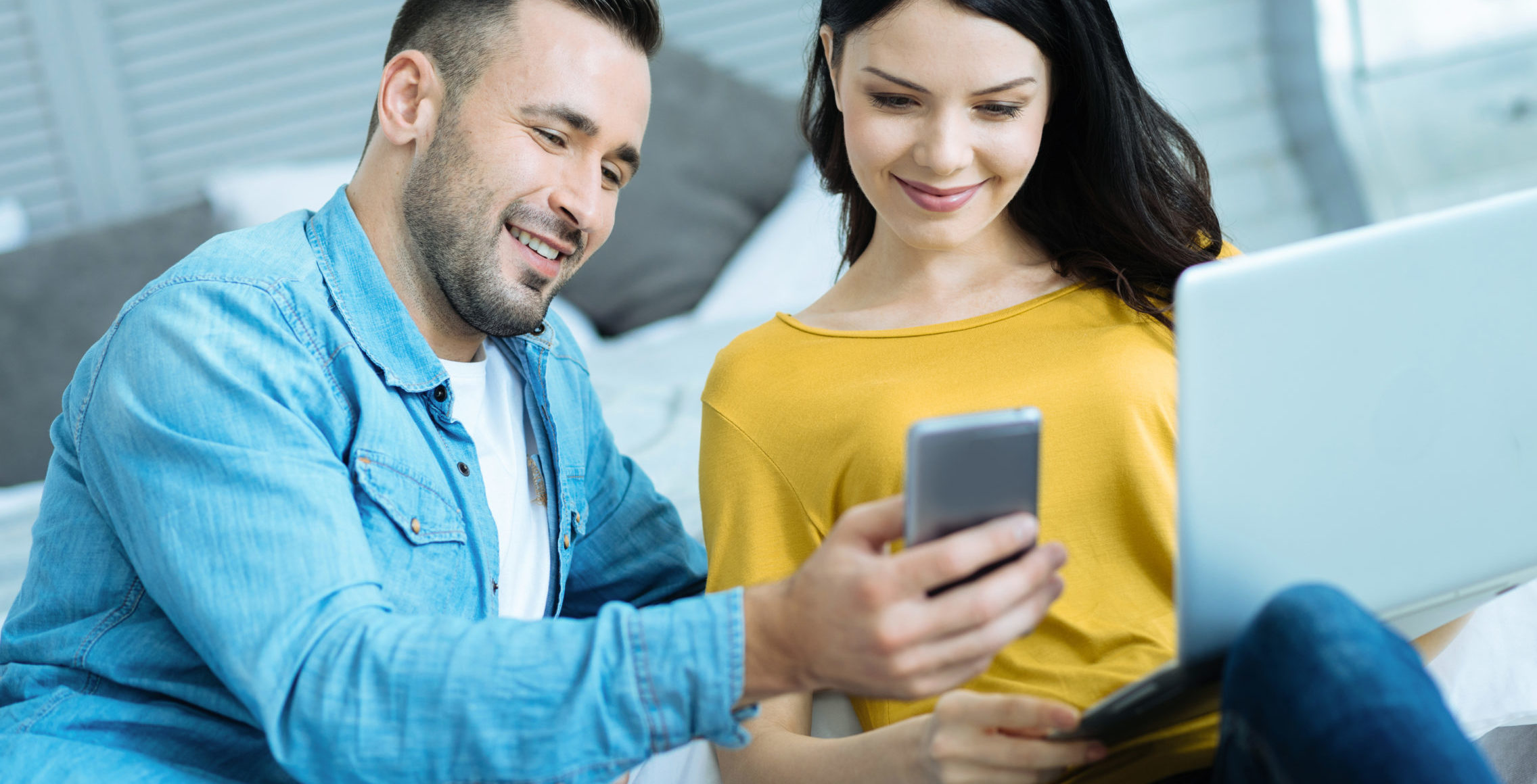man and woman looking at phone
