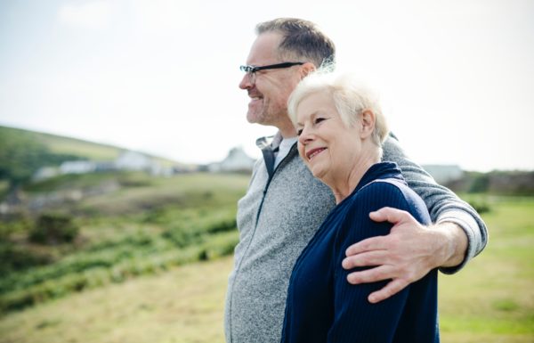 older couple hands over shoulder in embrace