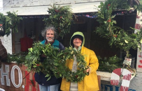 men holding holiday wreaths