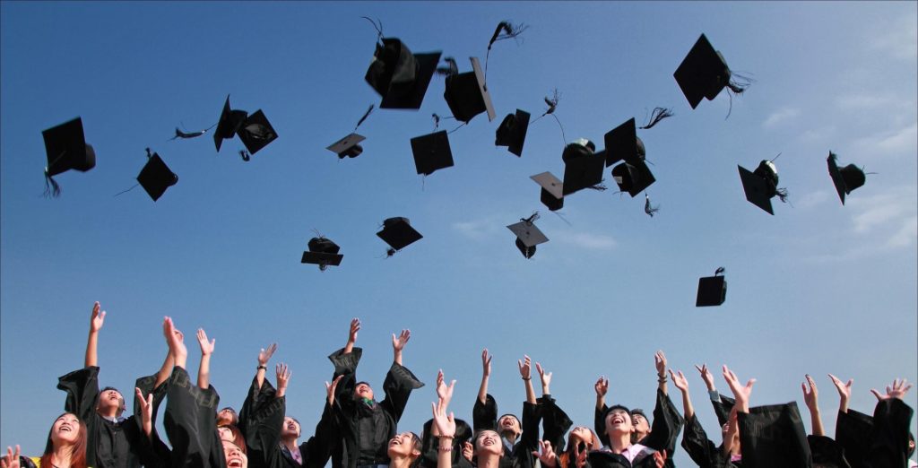 students throwing graduation caps