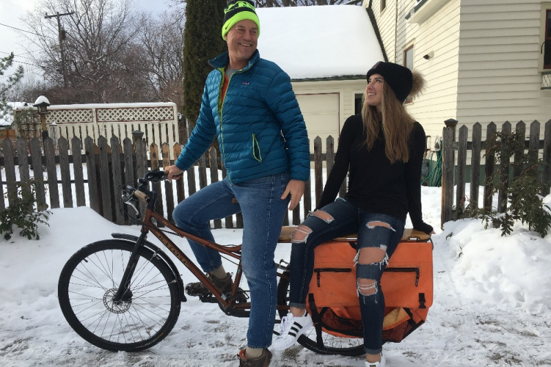 young couple sitting on a bike in the snow