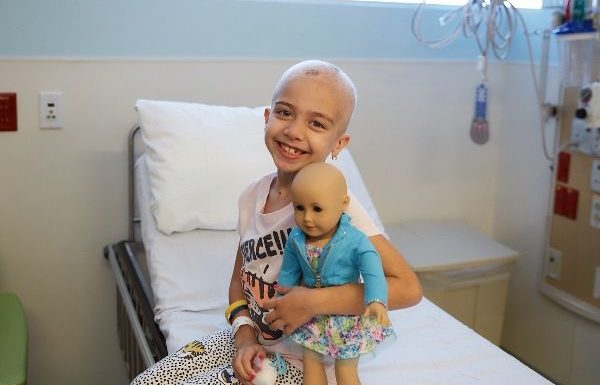 niña con cáncer posando con un muñeca