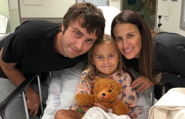 two parents posing with their daughter in the hospital