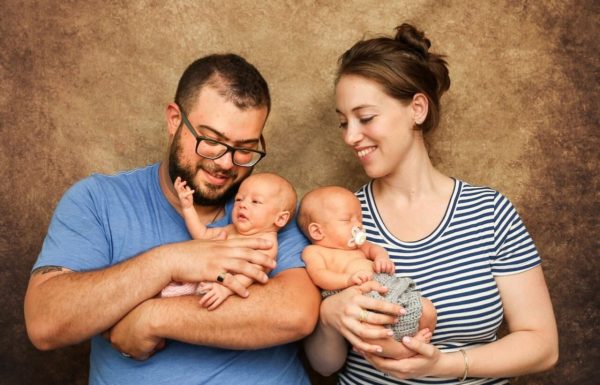 two parents holding twin babies