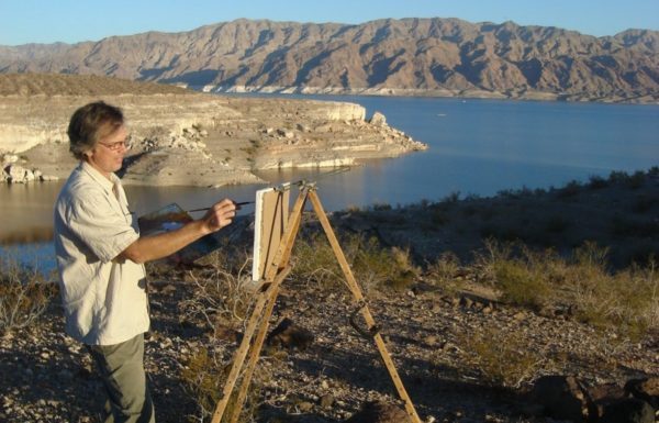 a man paints a nature scene near a lake