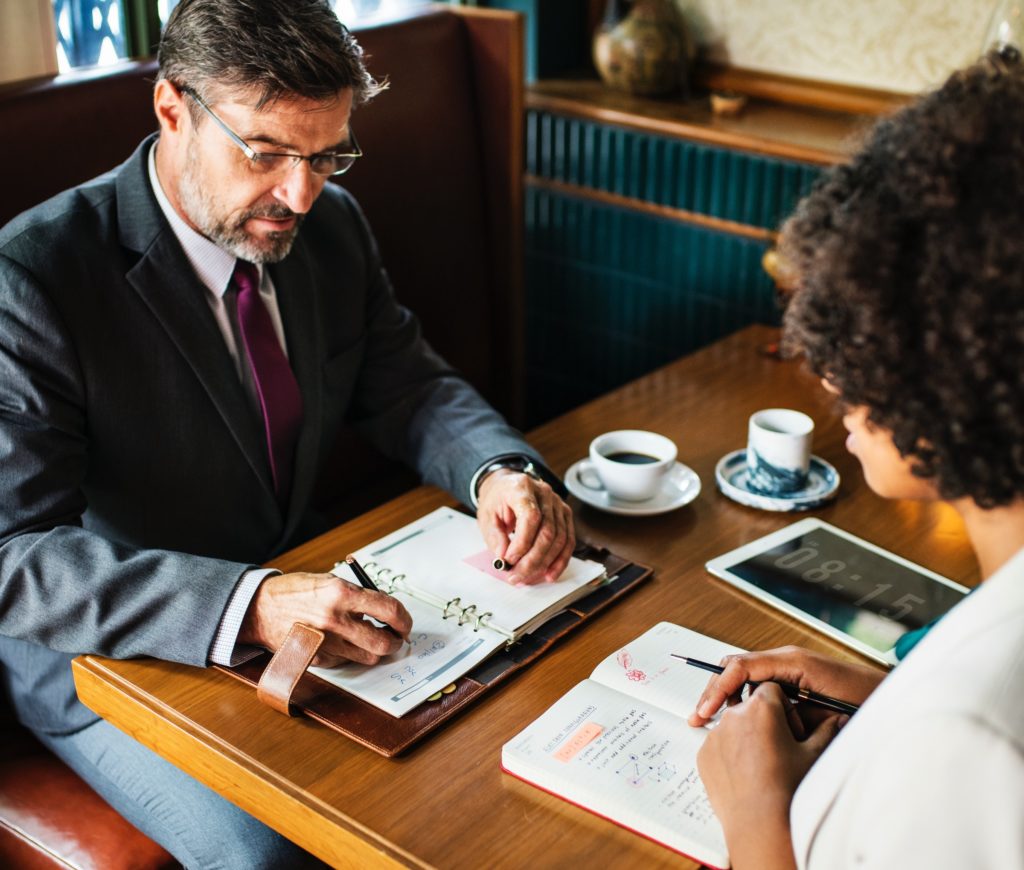 A man and a woman sitting at a table working.