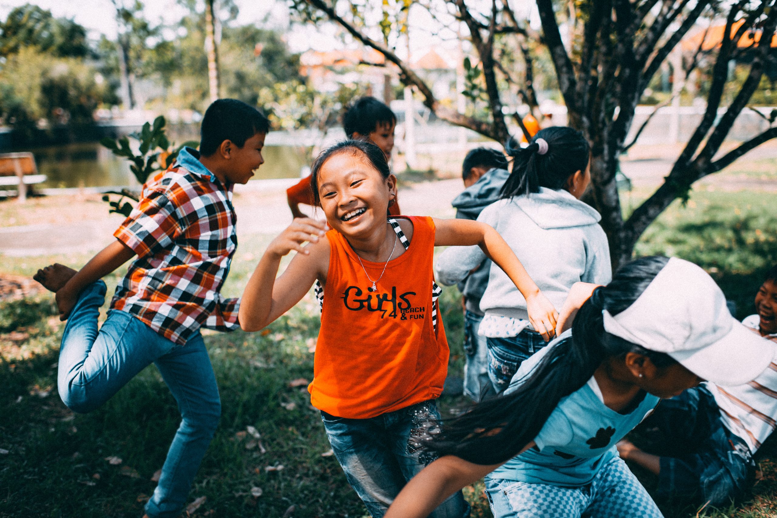 A group of children running and playing in a park.