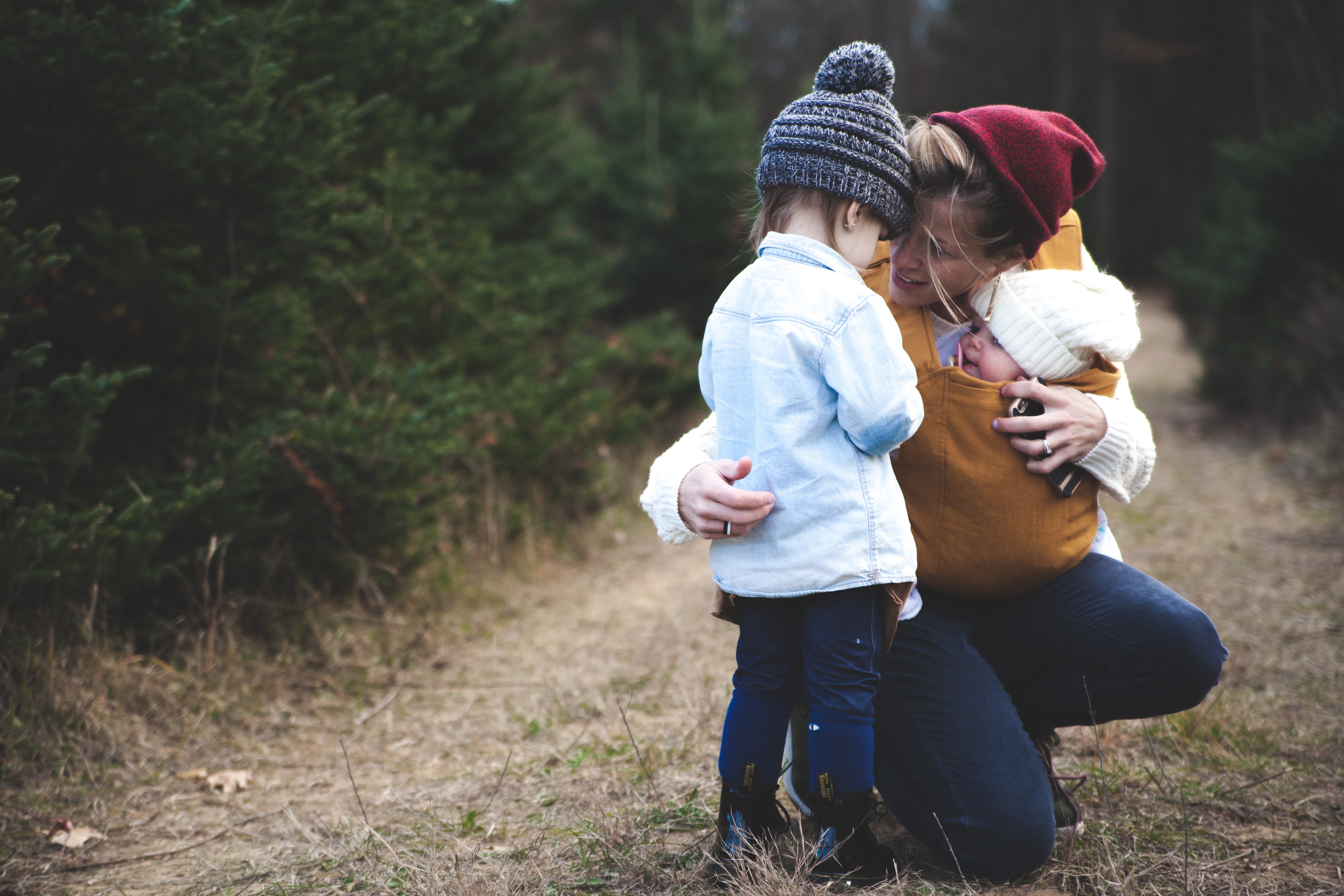 A mother hugging her two children