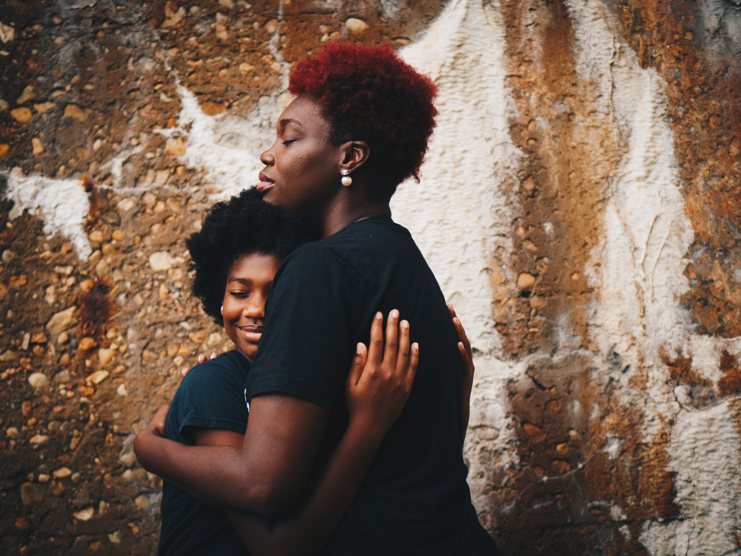 Two women in black shirts hugging
