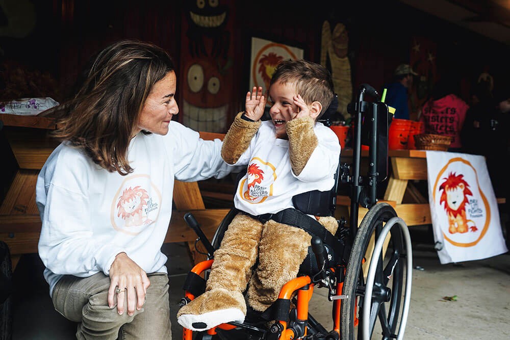 women interacting with young child in wheelchair