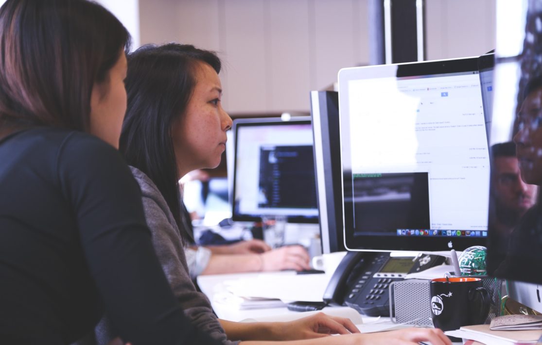 two woman looking at computer