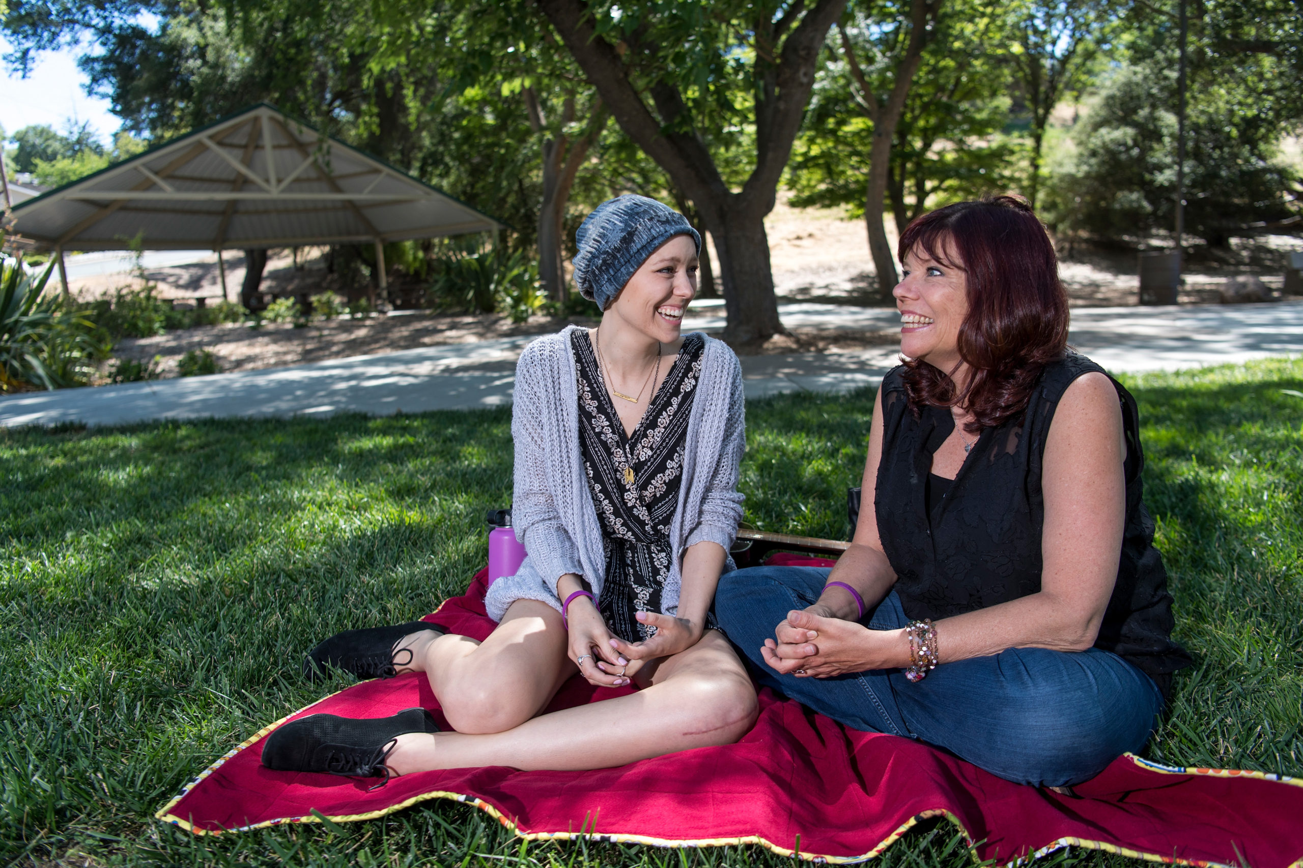 daughter and mother sitting outside on blanket