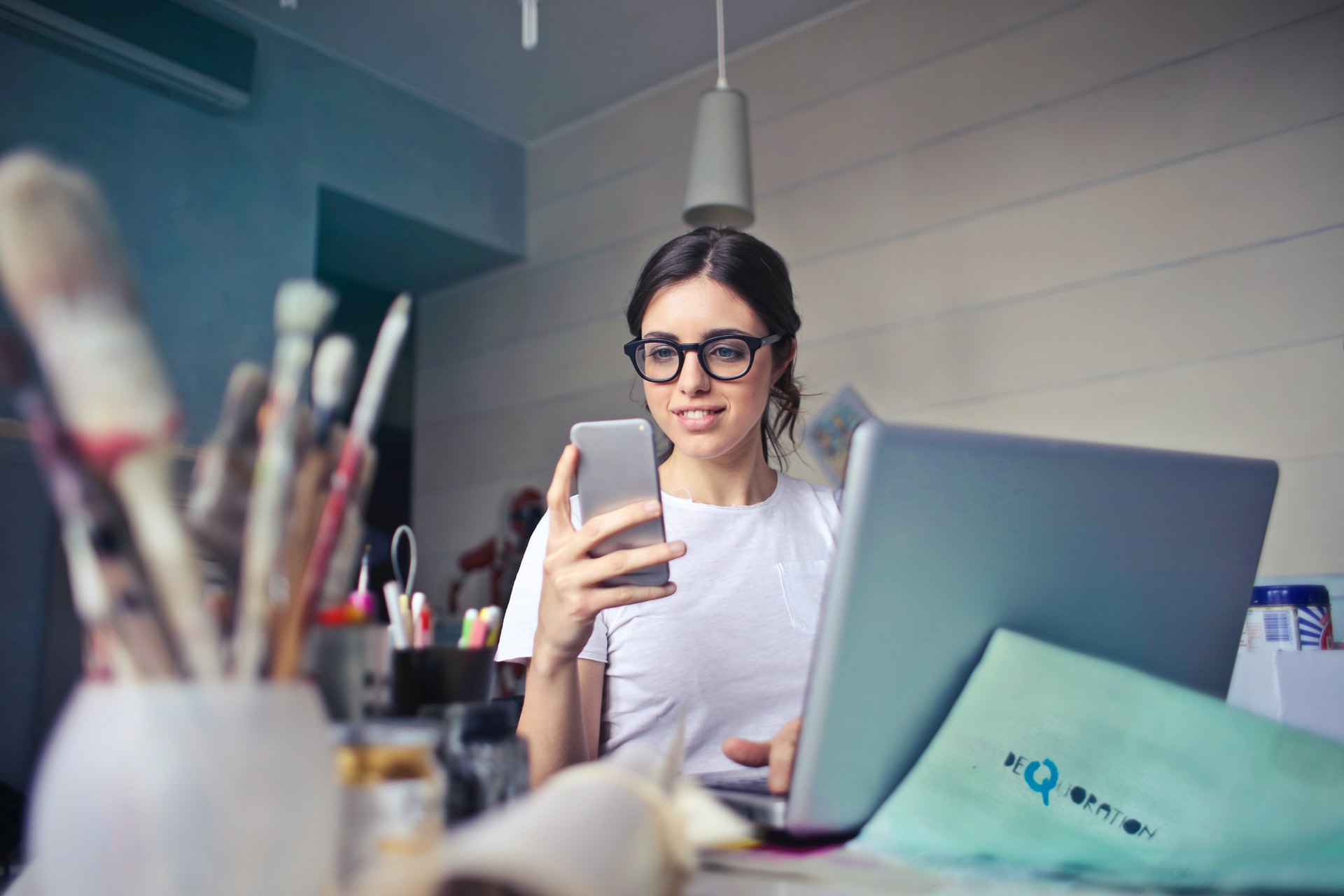 A woman wearing glasses sitting at her computer