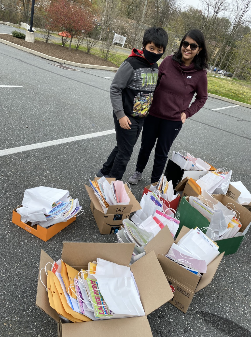 Young woman and young man standing next to boxes full of care packages