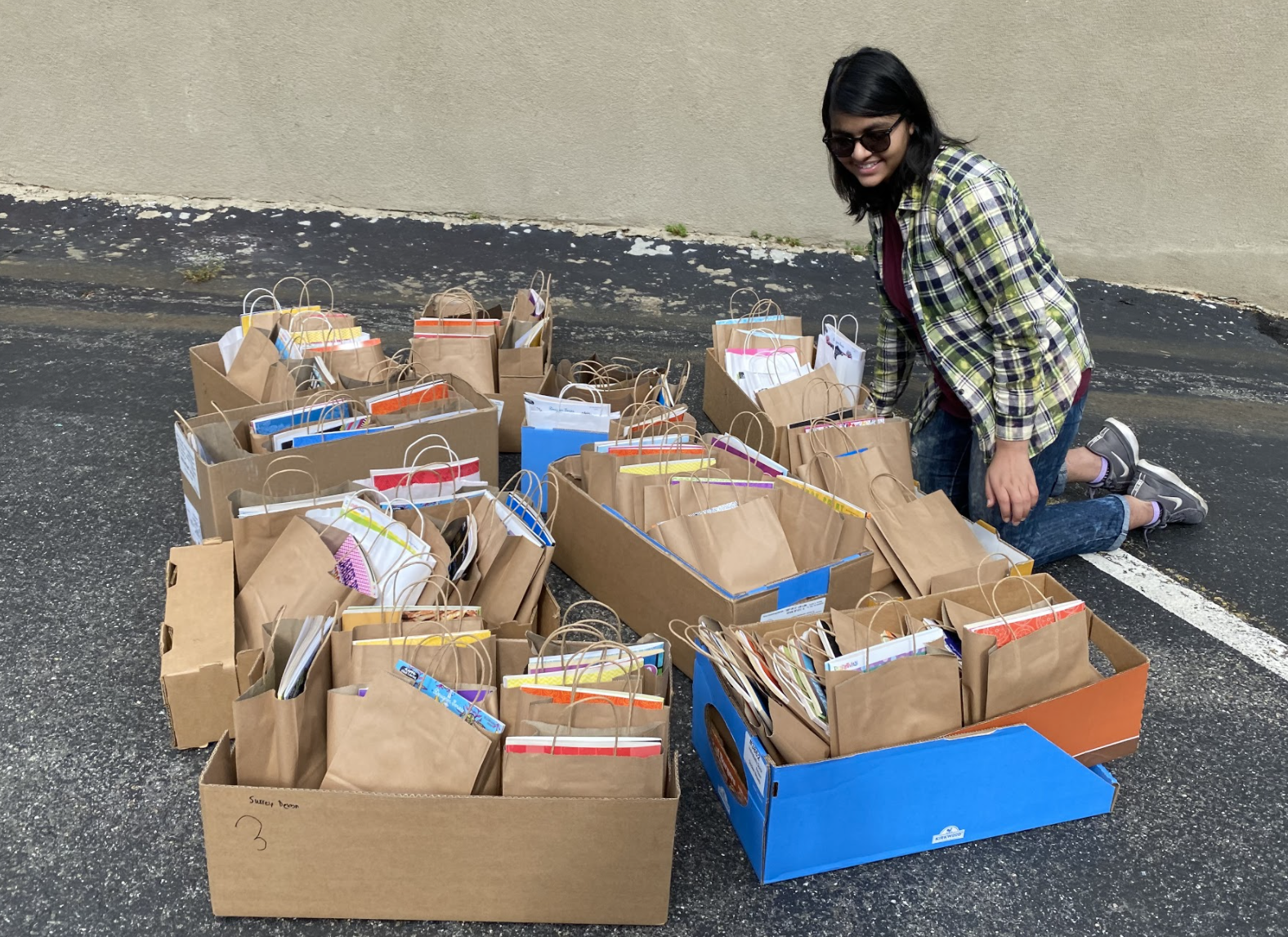 Young woman standing near boxes full of care packages