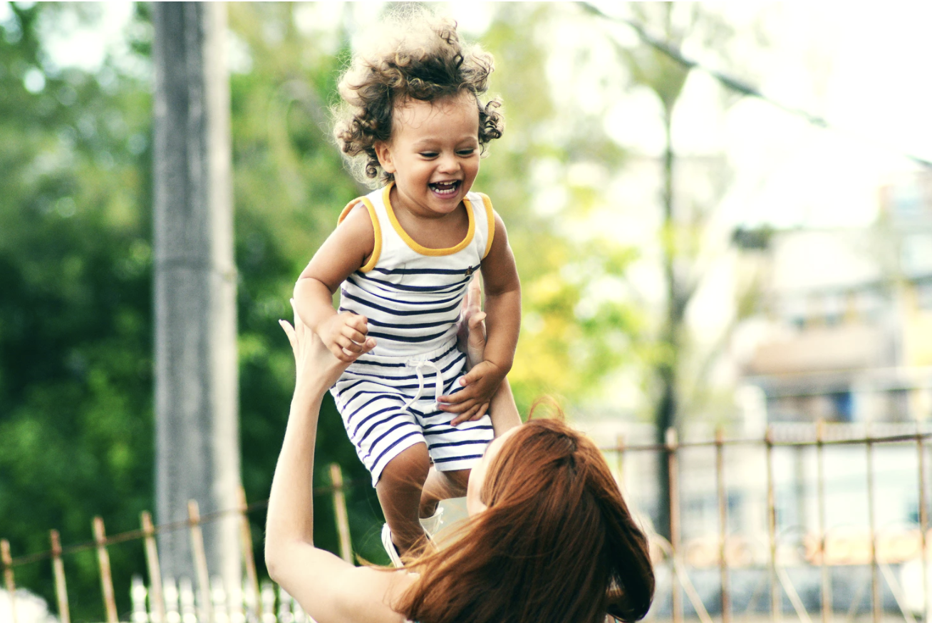 woman holding up toddler
