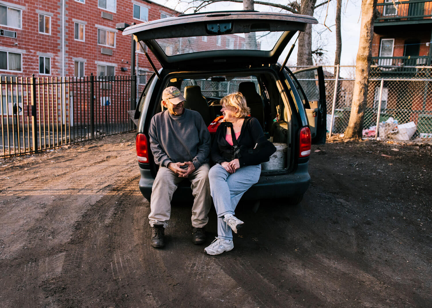 man and woman sitting in the back of a van