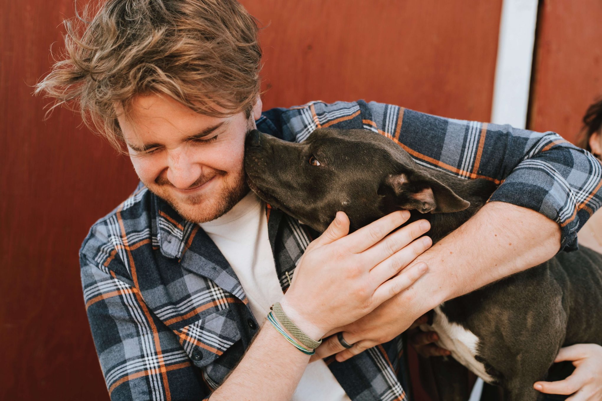 man hugs dog