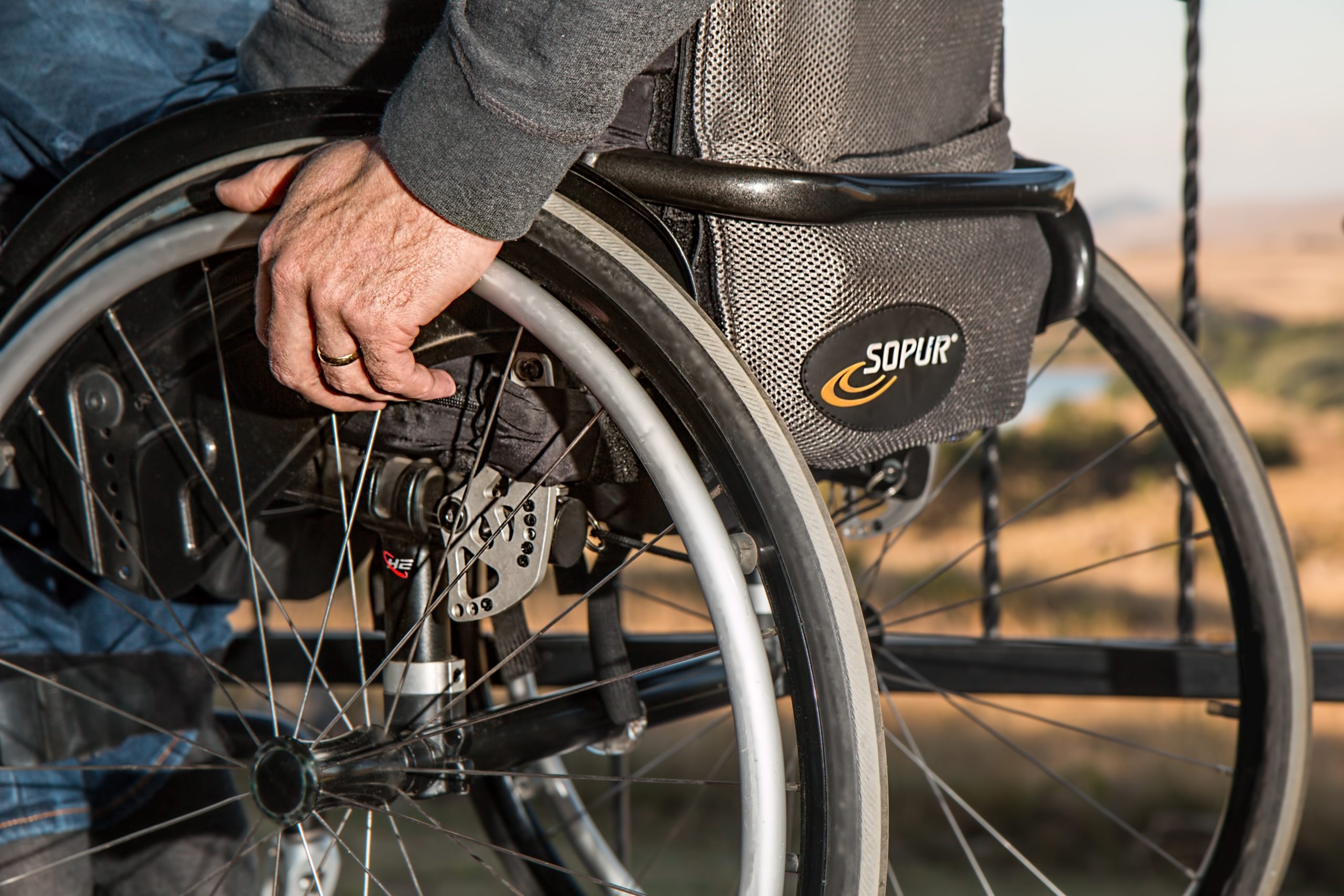 person with hand on wheelchair