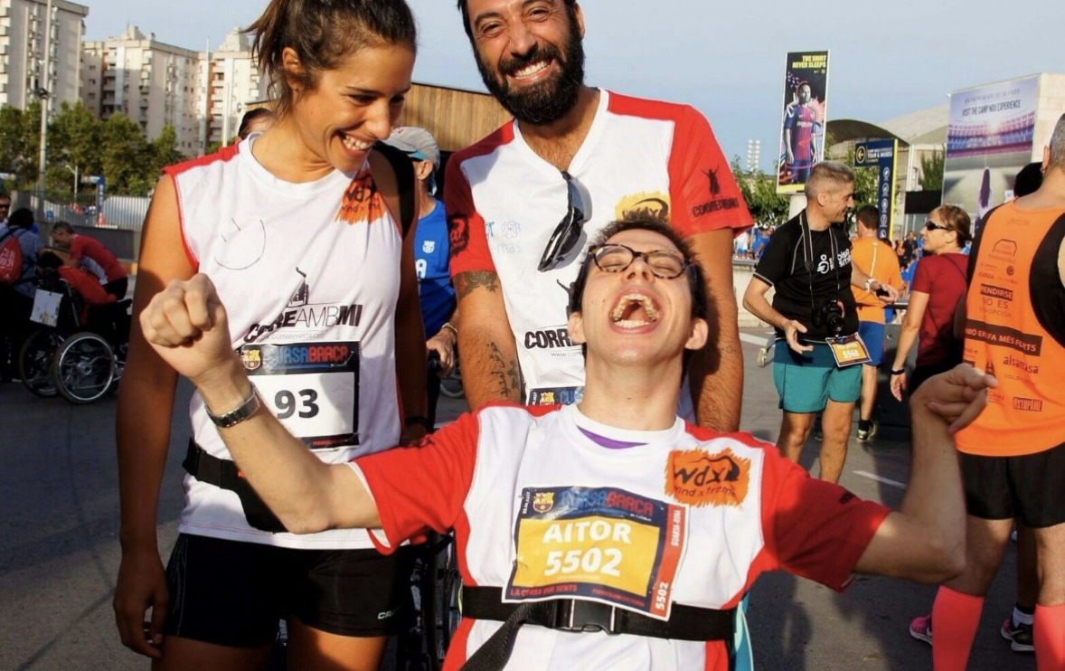 Niño en silla de ruedas y adultos participando en un maratón