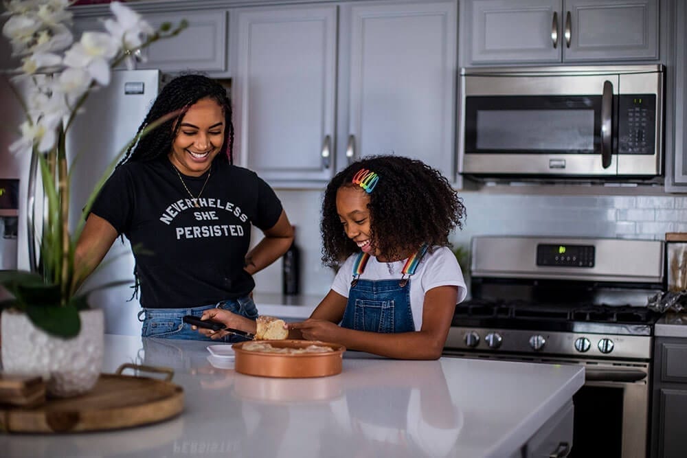 woman and girl making something in the kitchen