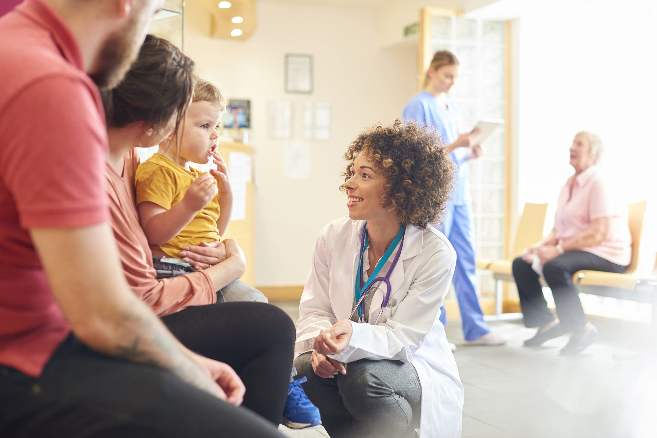 female doctor speaking to family with small child