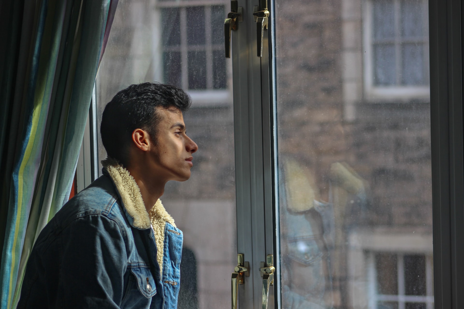 young man looking out of a window