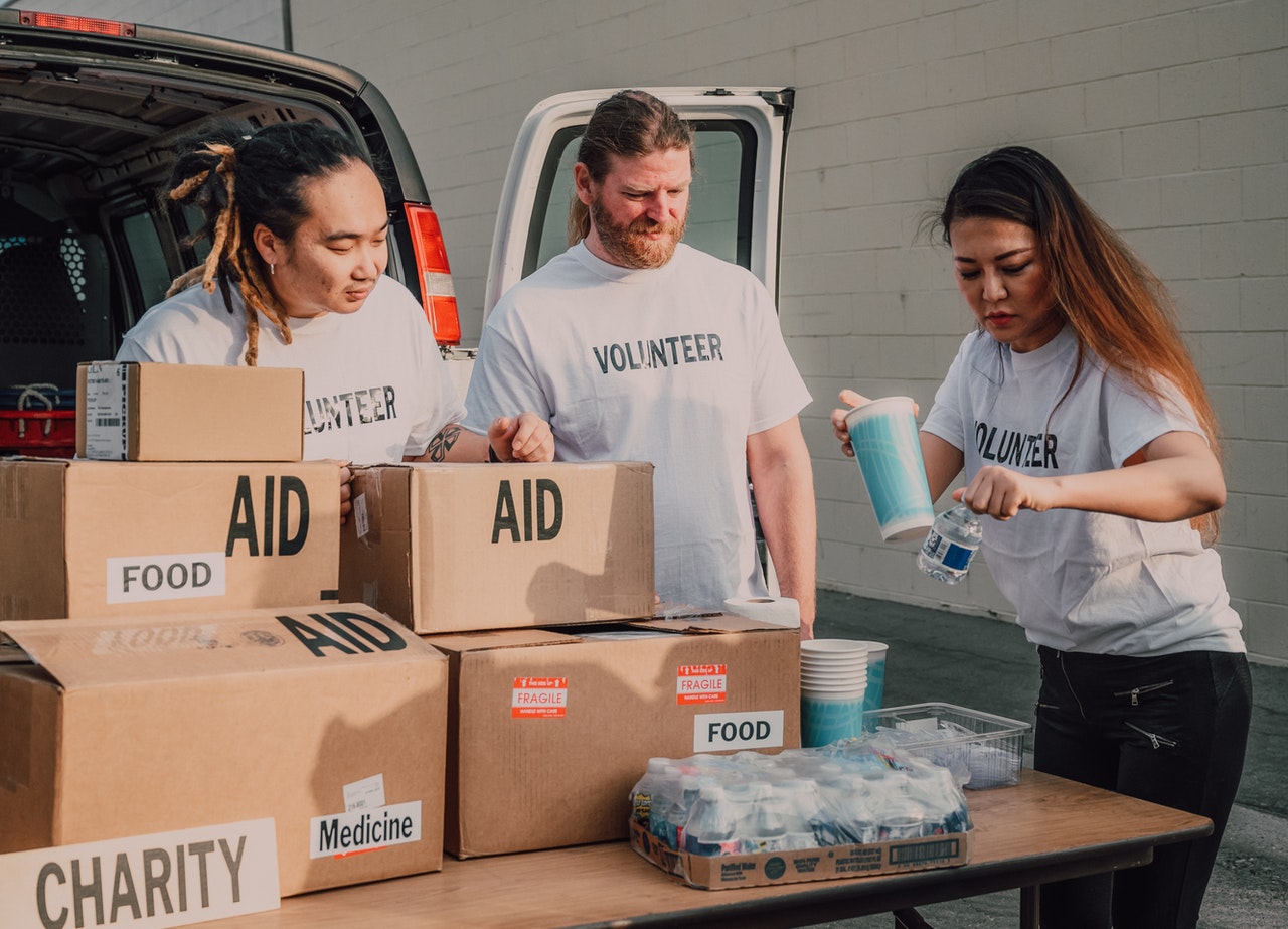 Three volunteers packaging food
